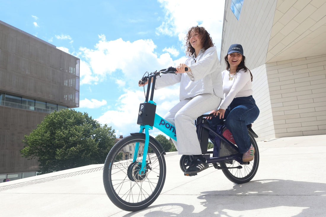 a couple of women riding on the back of a blue bike